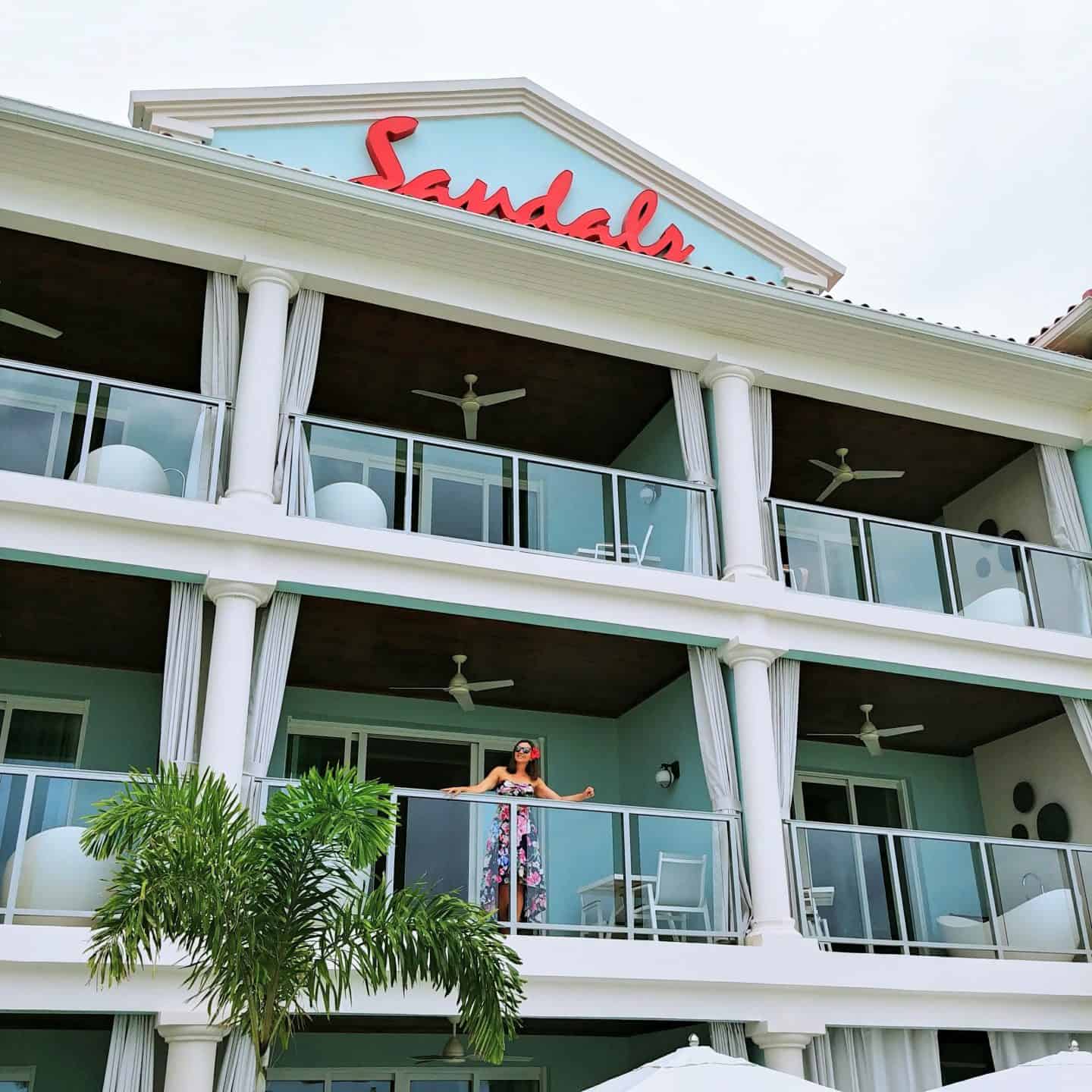 Luxury Couples Getaway - Sandals Montego Bay Jamaica room view off of balcony with bathtubs and red sandals sign in floral dress