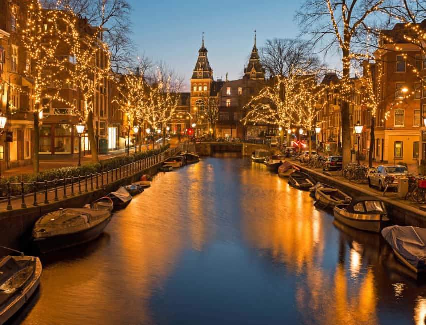 amsterdam best christmas markets in europe at night with golden lights and histoic buidlings in background