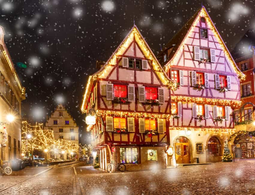 colmar best christmas markets in europe at night with golden lights and histoic buidlings in background