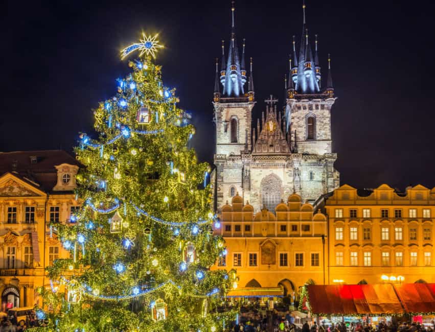 prague best christmas markets in europe at night with golden lights and histoic buidlings in background