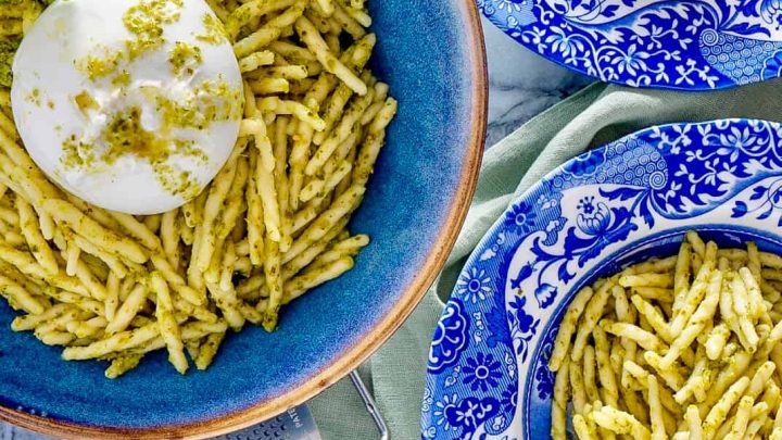 trofie al pesto Trofie alla Genovese plated on blue plates with burata cheese