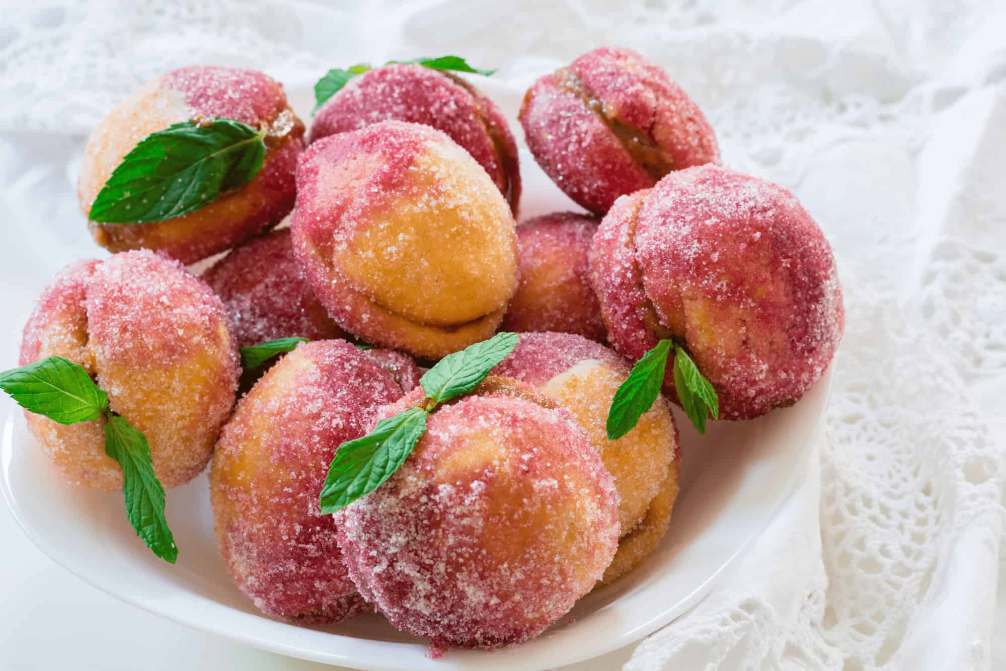 Croatian peach cookies breskvice on a plate dusted with sugar