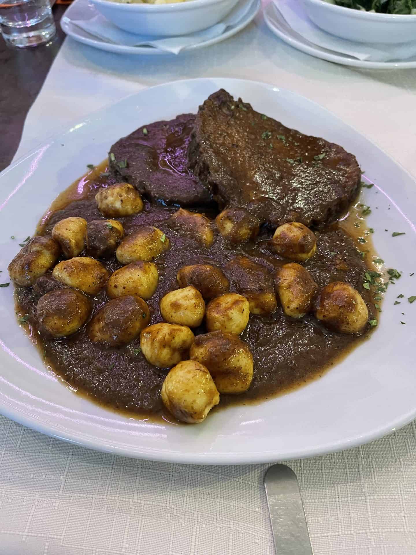 A delicious traditional Croatian dish featuring tender braised beef, sautéed mushrooms, and crispy potatoes, perfect for a hearty meal in Croatia on a 7 day croatia itinerary