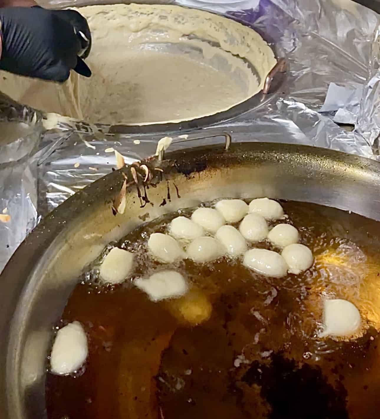 Golden brown jalebi frying in oil, traditional Indian sweet dessert.