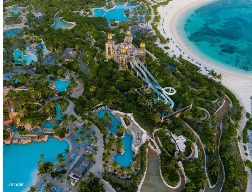 Luxurious water park with thrilling slides, lush greenery, and scenic beach views at Atlantis resort, Bahamas.