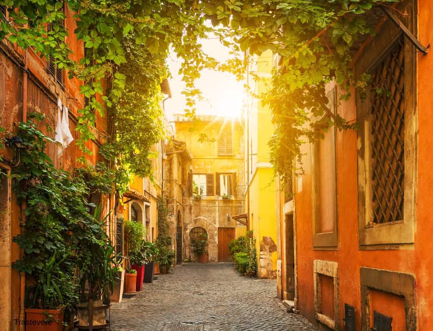 Cobblestone street in Trastevere with fairy lights and cozy trattorias in winter