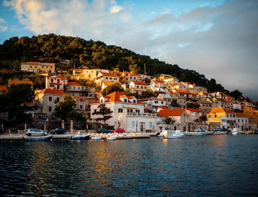 bol brac croatia waterfront promenade with palm trees and stone houses
