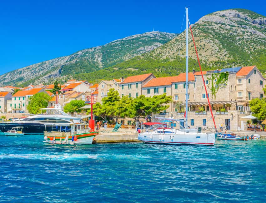 Bol Brac Croatia waterfront promenade with stone houses and turquoise sea