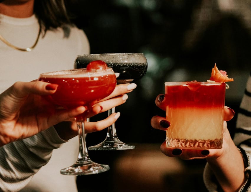 people cheering at christmas with christmas cocktails