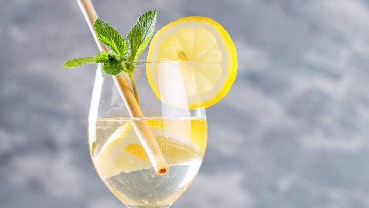 Limoncello spritz cocktail Bright yellow limoncello spritz served in a stemmed wine glass with lemon slices, prosecco bubbles, and fresh mint. #limoncellospritz #spritz
