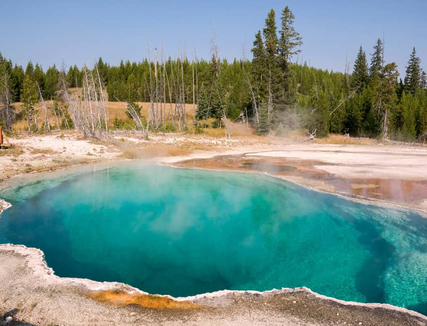 crystal blue lake with steam in yellowstone