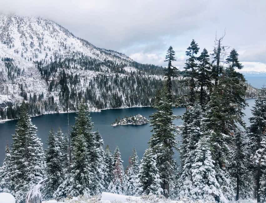 view of lake tahoe snowy mountains and pine trees