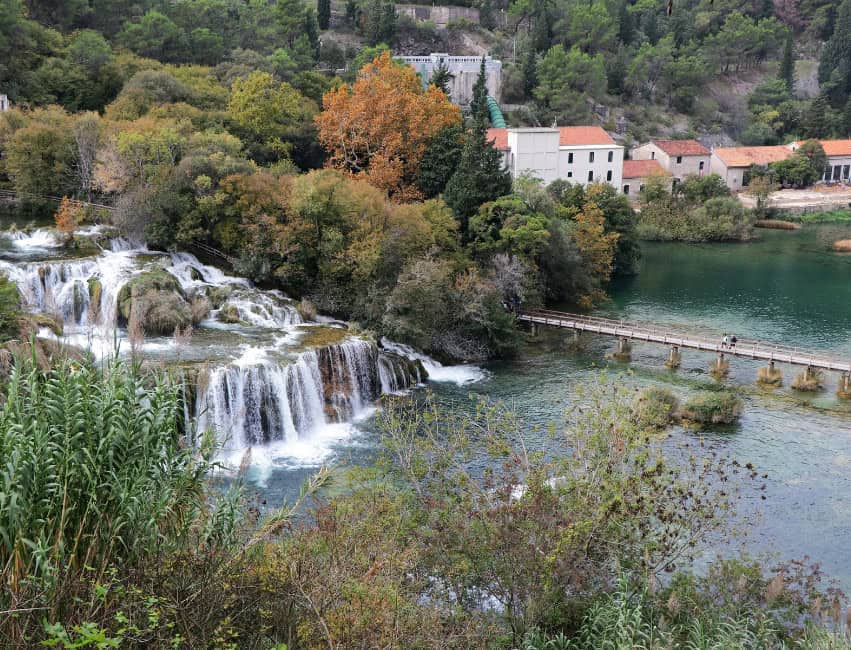 Wooden boardwalk hiking trail through lush forest at Krka National Park
