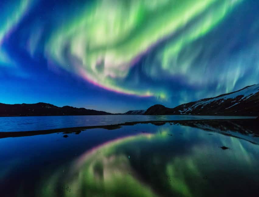 Northern Lights glowing above Reykjavik Iceland