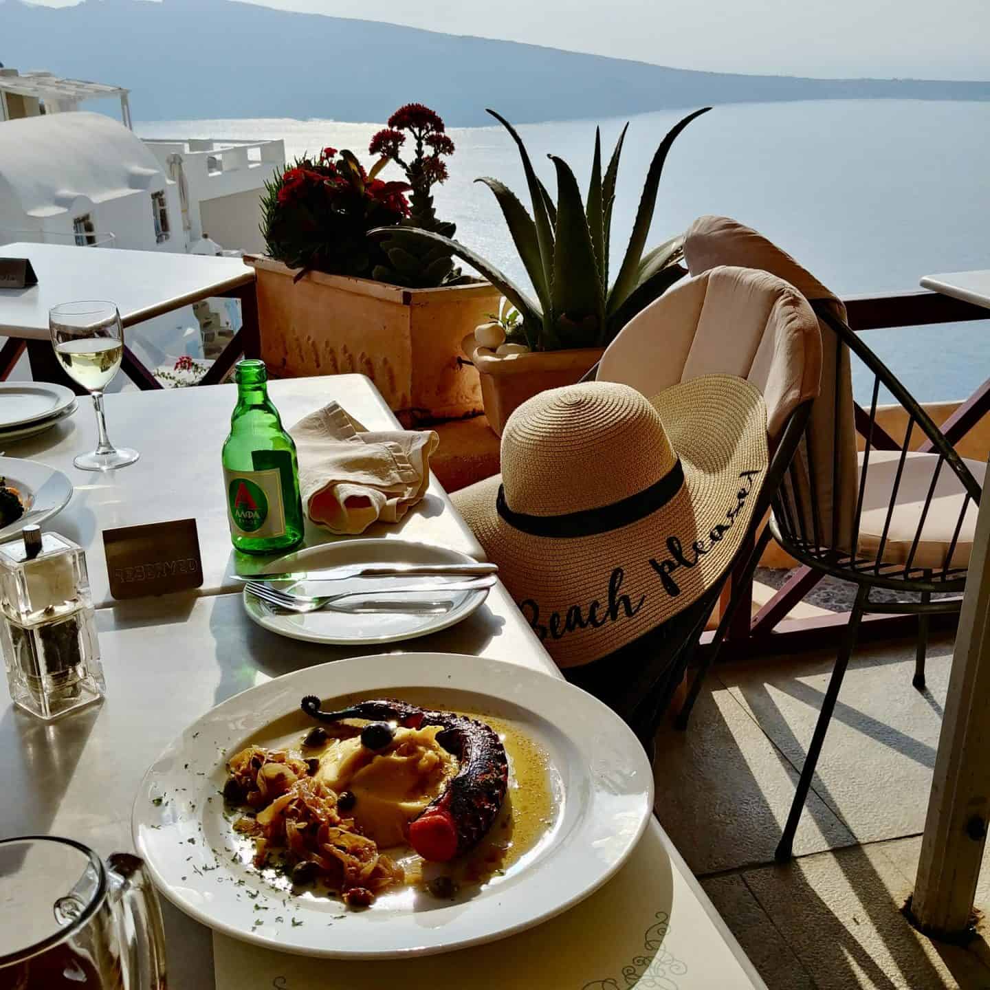 lunch of grilled octopus overlooking oia santorini greece