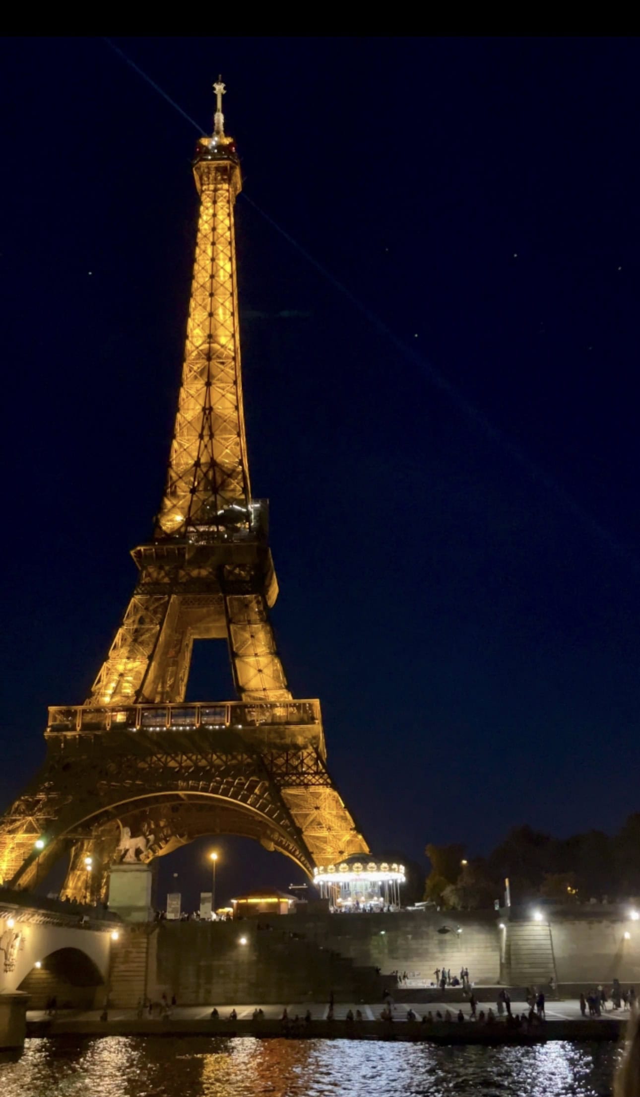 Eiffel Tower sparkling lights at night view from seine river cruise