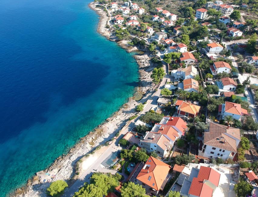 Charming coastal village on Solta Island with clear blue waters and colorful houses.
