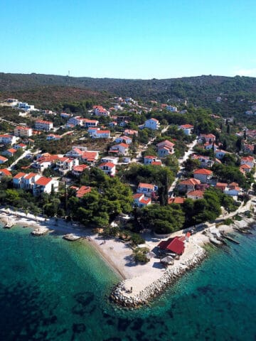 Aerial view of Solta Island with colorful houses and clear blue waters. Perfect for a relaxing Croat.